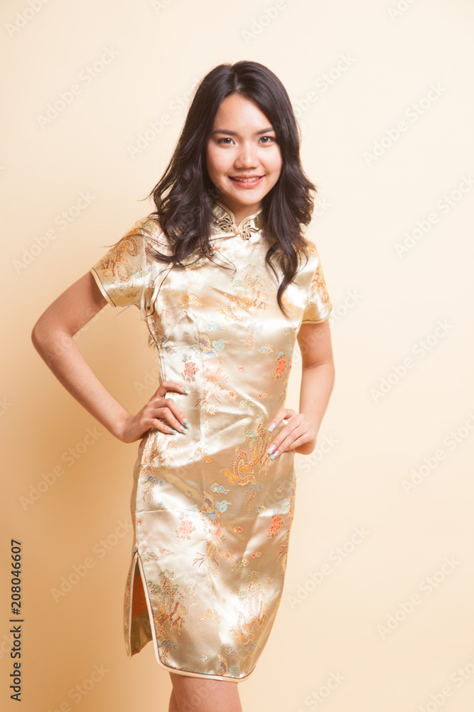 Portrait of Asian girl in golden chinese cheongsam dress Portrait of Asian girl in golden chinese cheongsam dress