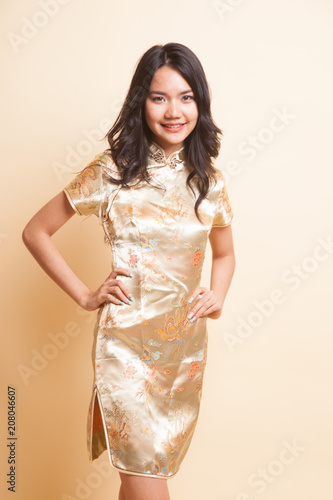 Portrait of Asian girl in golden chinese cheongsam dress