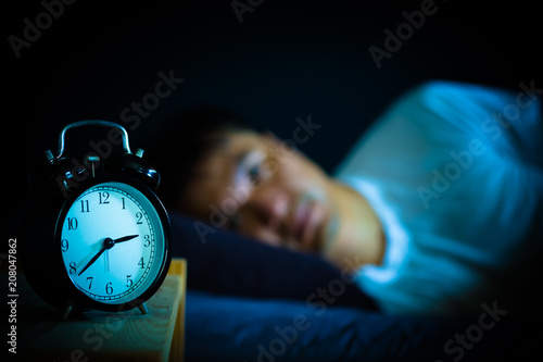 Canvas Print asian man in bed suffering insomnia and sleep disorder thinking about his proble