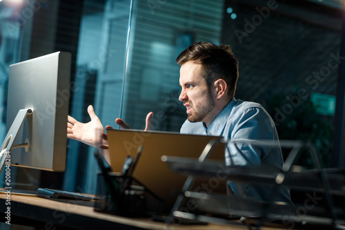 Quadro em tela Man screaming at computer with anger suffering from malfunction of gadget while