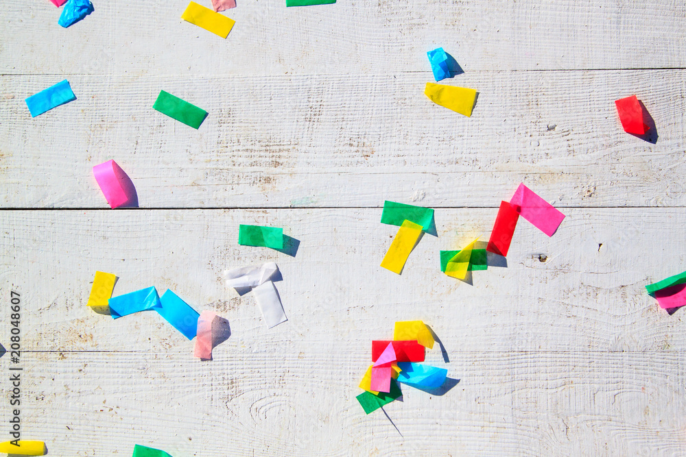 Obraz premium multicolored confetti on the white painted wooden floor or table background