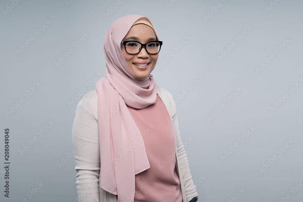 a malay woman using gadget on gray background a malay woman using gadget on gray background