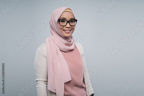 a malay woman using gadget on gray background