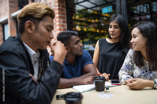 a group of multi culture friends discussing work at cafe