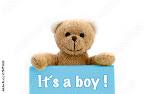 It´s a boy message written on blue card with brown teddy bear holding with the two hands the note with the message. Photo isolated in a seamless white background. Concept for newborn baby boy. © fewerton