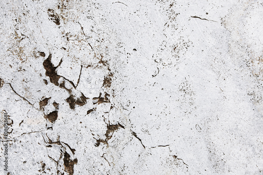 Cracked grungy white stone wall with imperfections and holes as simple texture background Cracked grungy white stone wall with imperfections and holes as simple texture background