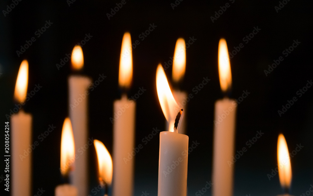 Devotional candles lit inside a church. Devotional candles lit inside a church.