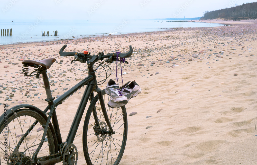 Fototapeta premium Bike on the beach. Sneakers hanging on the bike. Sea and bike.