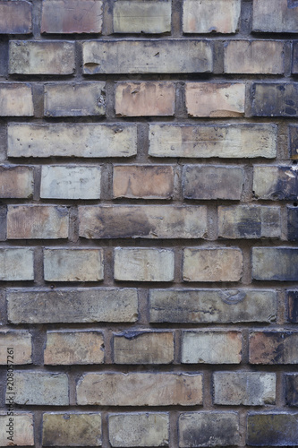 old brick wall of bricks of different colours closeup.