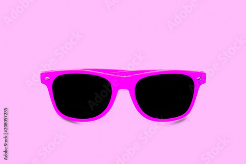 Summer pink sunglasses isolated in seamless pink background. Minimal design element for sun protection, hot days, tropical travel, summer vacations and beach holidays.