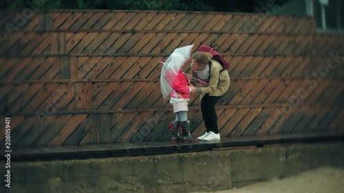 Wallpaper Mural Little beautiful girl and her mother with umbrella playing in the rain Torontodigital.ca