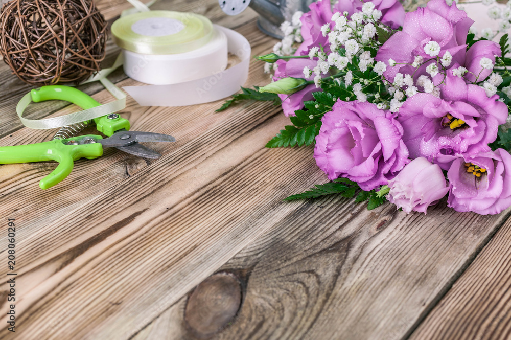 Workplace florist. Flowers and accessories for making bouquets on a wooden background Workplace florist. Flowers and accessories for making bouquets on a wooden background