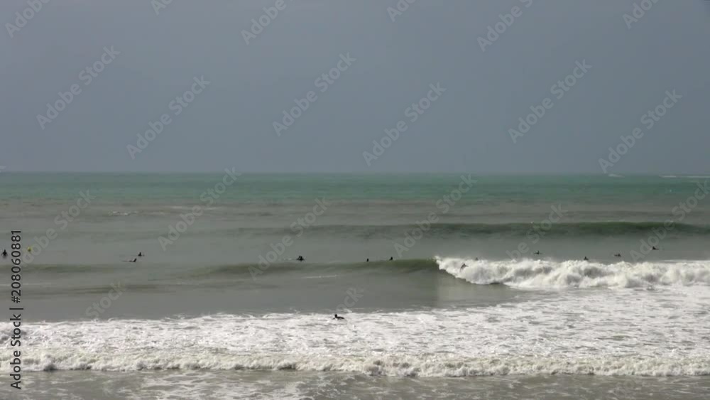 Three Surfers Catching Waves in Cadiz, Spain Three Surfers Catching Waves in Cadiz, Spain