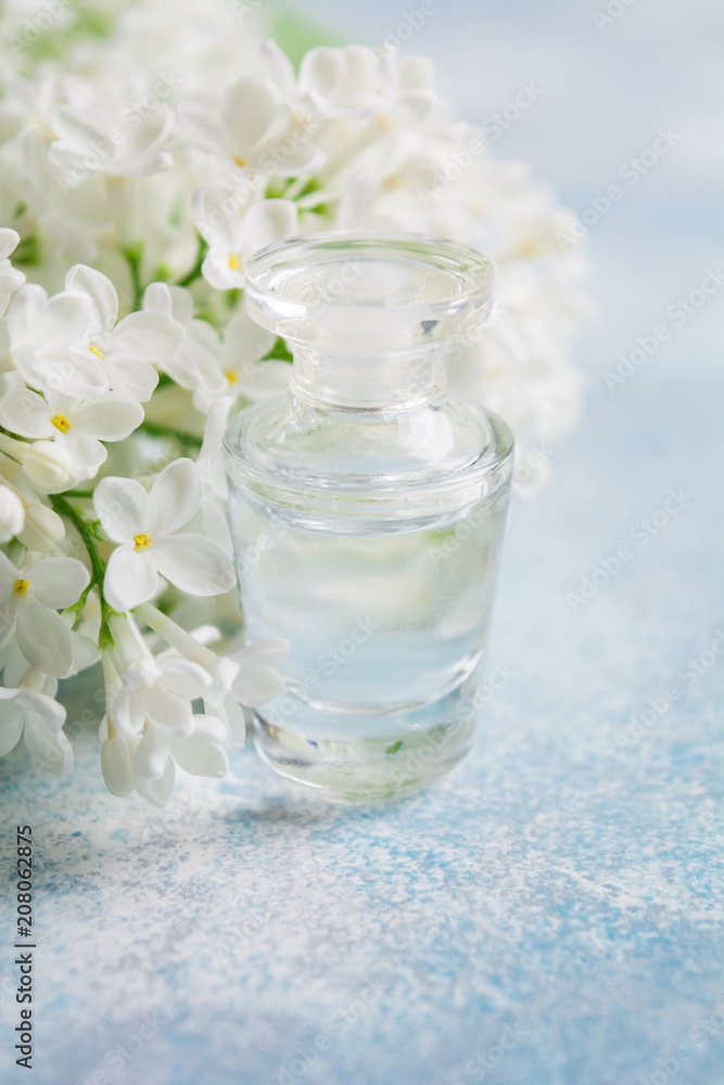 Close up view of small perfume bottle with white lilac Close up view of small perfume bottle with white lilac