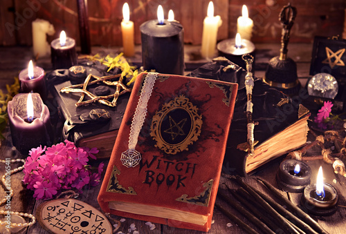 Witch books, black candles with magic and mystic objects on planks. Occult, esoteric and divination still life. Halloween background with vintage objects