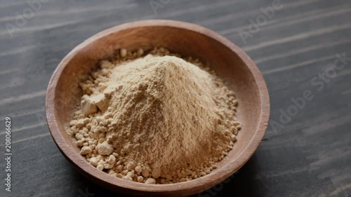 Rotating superfood maca powder in wooden bowl