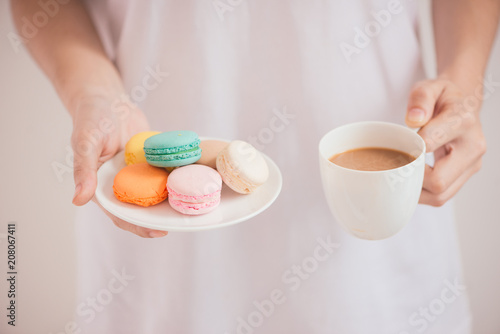 Hands holding colorful pastel cake macarons or macaroons
