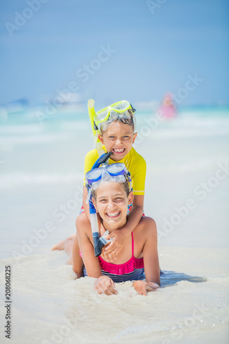 Brother and sister in scuba masks playing on the beach during the hot summer vacation day. © Max Topchii