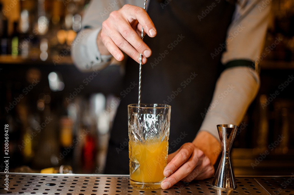 Bartender stirring an alcoholic drink in the glass