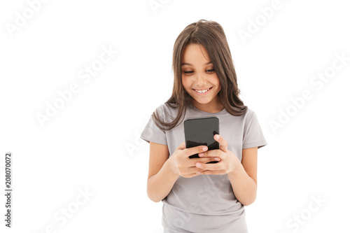 Cute girl standing isolated using mobile phone.
