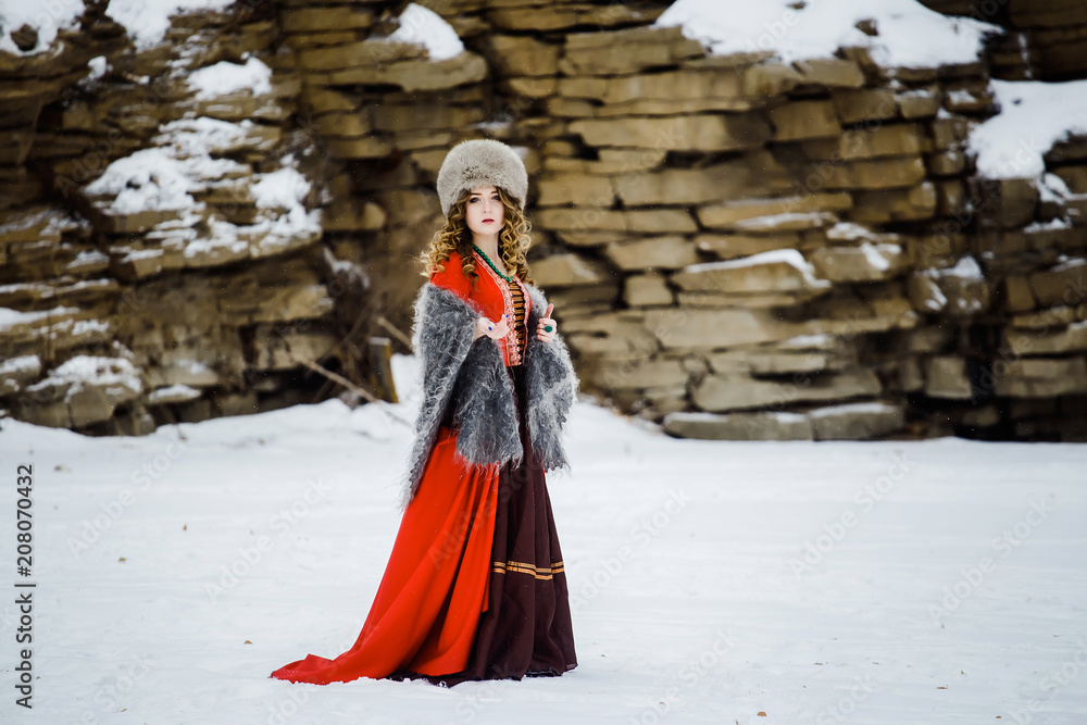 Beautiful young woman in national Russian dress walking in the woods Beautiful young woman in national Russian dress walking in the woods