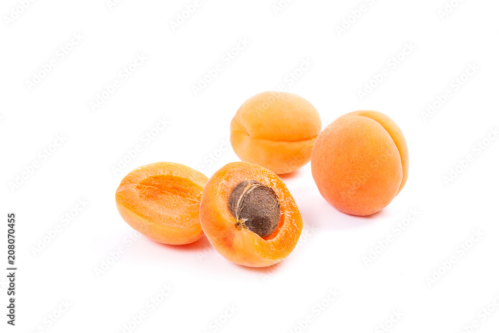 Several of harvested apricots whole and halved on white background.. Several of harvested apricots whole and halved on white background..