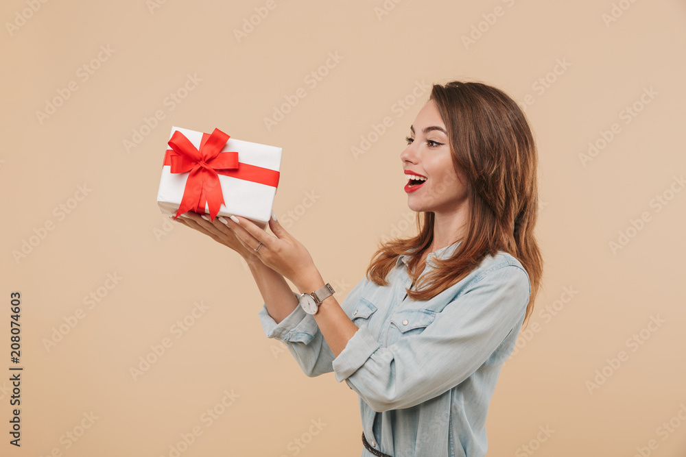 Portrait of an excited young girl looking at present box Portrait of an excited young girl looking at present box