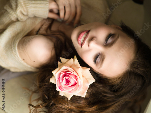 Girl with flower. Beautiful young woman holding red rose and smiling. photo