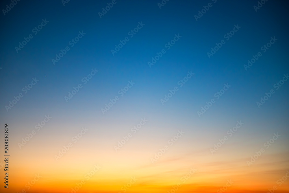 Naklejka premium Zachód słońca na niebie w dramatycznych kolorach niebieskim, pomarańczowym i czerwonym