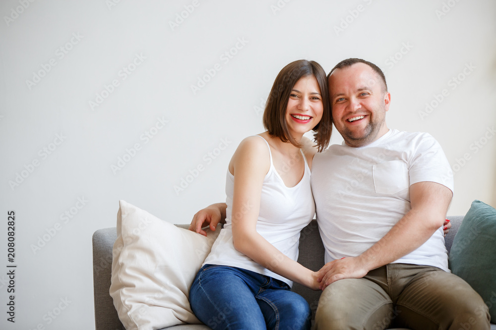 Picture of young married couple sitting on sofa Picture of young married couple sitting on sofa