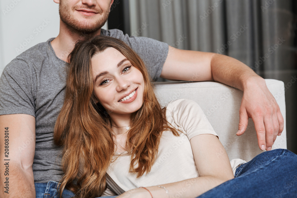 Hhappy young loving couple sitting on sofa