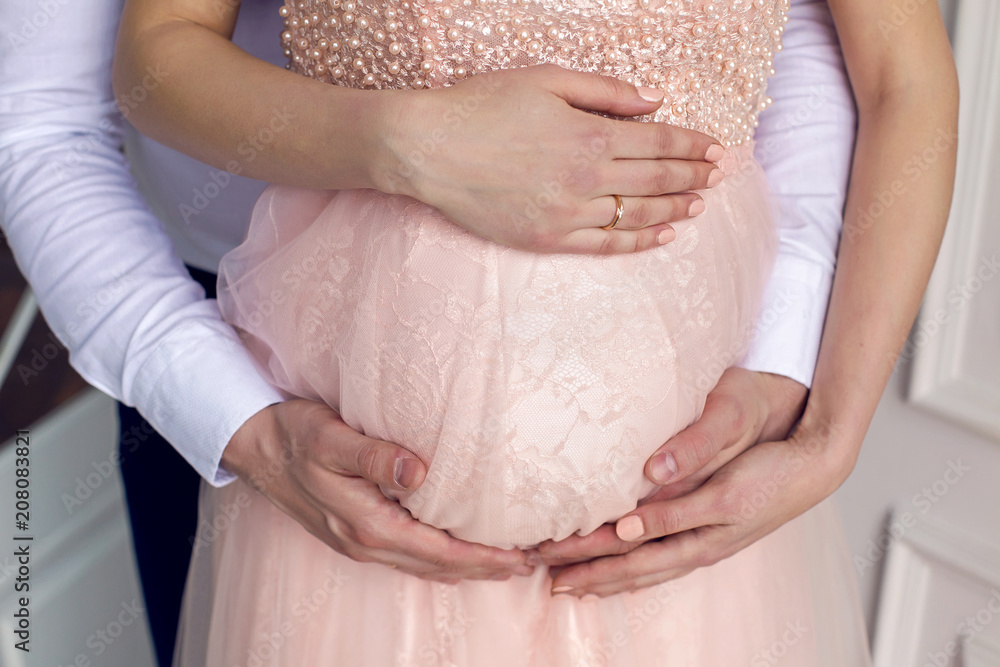 pregnant woman stands with her husband in the studio pregnant woman stands with her husband in the studio