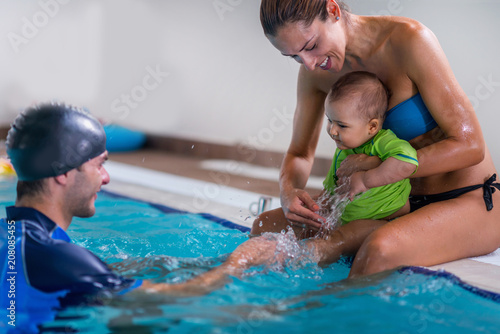 Mother with baby boy and instructor on swimming class © Microgen