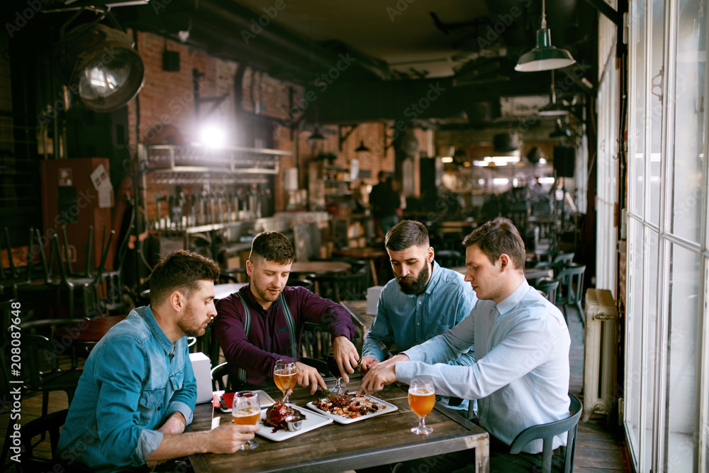 Men In Pub Drinking Beer And Eating Food Men In Pub Drinking Beer And Eating Food