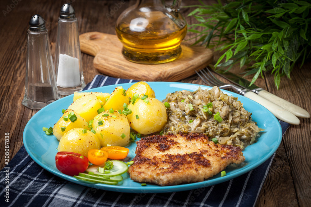 Fried pork chop, baked potatoes and fried young cabbage. Fried pork chop, baked potatoes and fried young cabbage.
