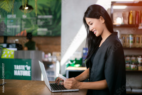 Young woman holding credit card and using laptop computer. Online shopping concept