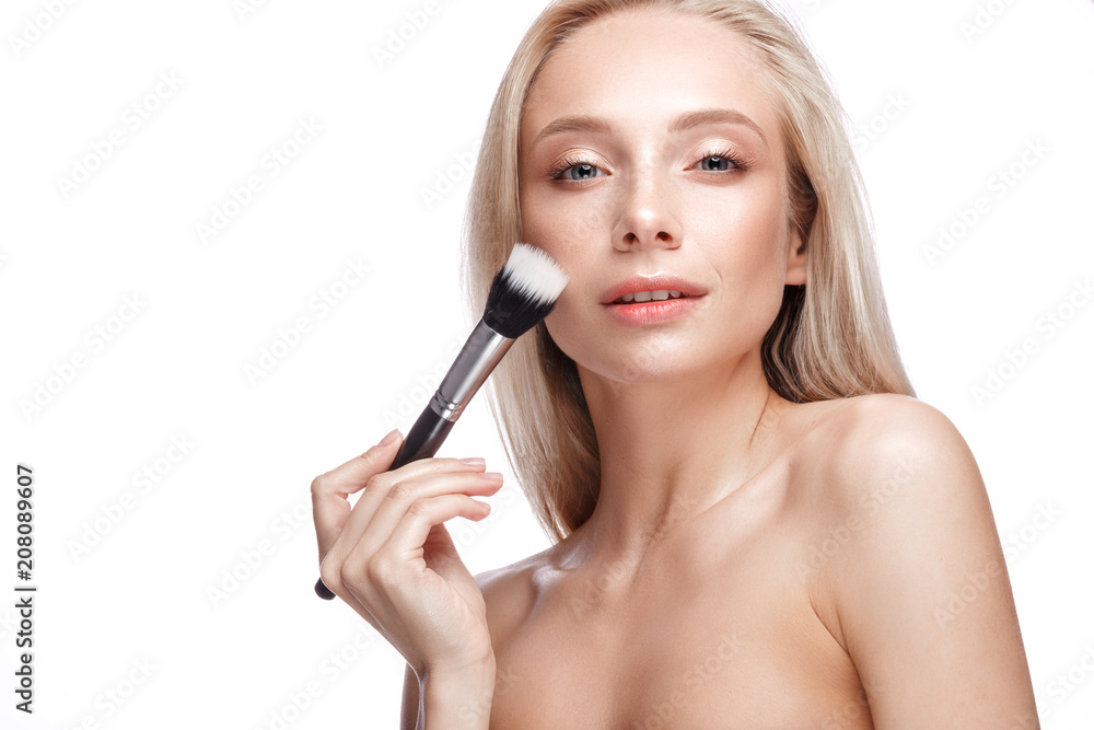 Beautiful young girl with a light natural make-up,brushes for cosmetics and nude manicure. Beauty face. Picture taken in the studio on a white background. Beautiful young girl with a light natural make-up,brushes for cosmetics and nude manicure. Beauty face. Picture taken in the studio on a white background.