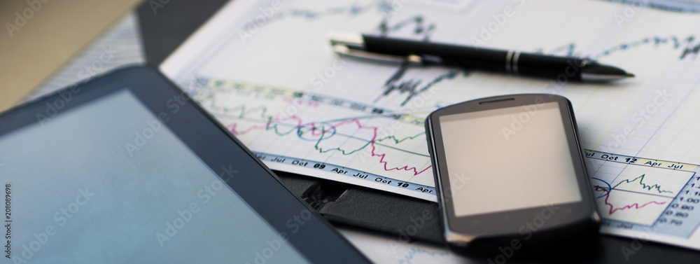 Close up image of tablet with a phone and a schedule with pen at workplace Close up image of tablet with a phone and a schedule with pen at workplace