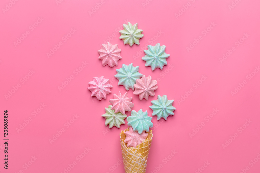 Ice cream cone with pink,blue, yellow meringues on a  colorful  background. Sweet summer concept. Top view. Flat lay.Pastel colors.Dessert
