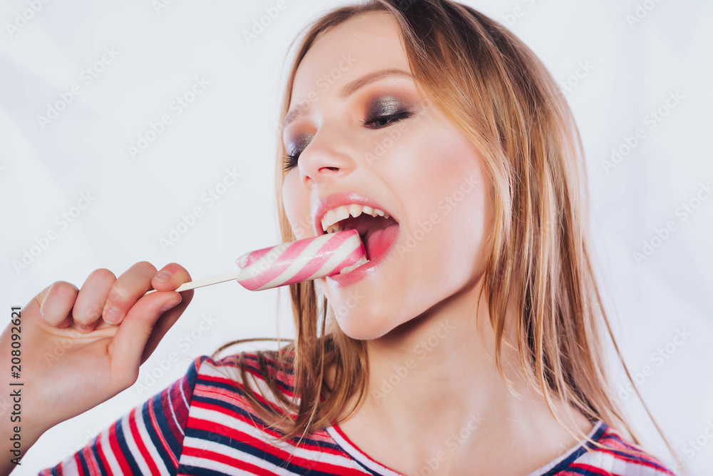 Portrait of a happy pretty girl holding sweet candy.Funny woman holding big lollipop. Birthday party.Beautiful woman with creative makeup holding a candy, closeup portrait Portrait of a happy pretty girl holding sweet candy.Funny woman holding big lollipop. Birthday party.Beautiful woman with creative makeup holding a candy, closeup portrait