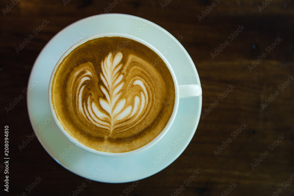 top view of Coffee cup with latte art on wooden table . Selective focus white cup.color vintage style. top view of Coffee cup with latte art on wooden table . Selective focus white cup.color vintage style.