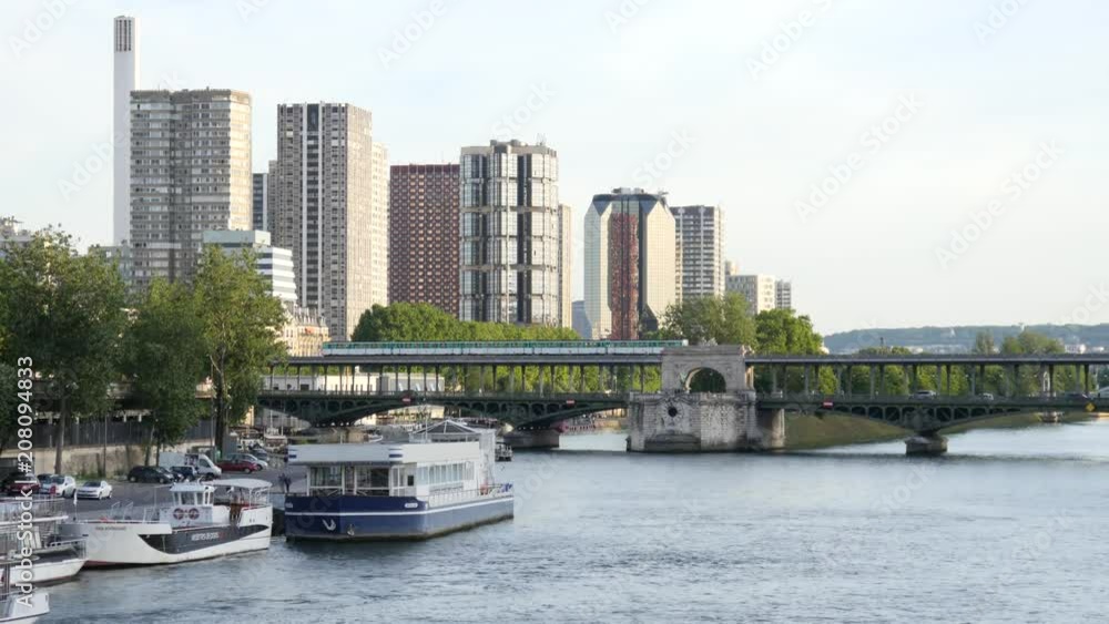 Paris river Seine and high business buildings with Metro train goes over the bridge in evening Paris river Seine and high business buildings with Metro train goes over the bridge in evening