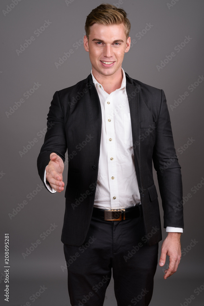 Fototapeta premium Young handsome businessman with blond hair wearing suit against 