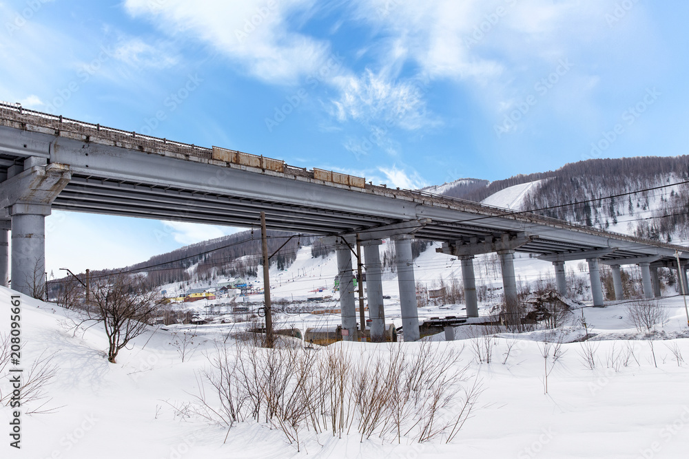 The car bridge over the railway. Winter mountains The car bridge over the railway. Winter mountains