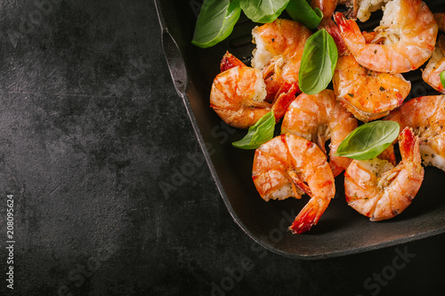Fotografía Grilled king prawns on pan on dark table