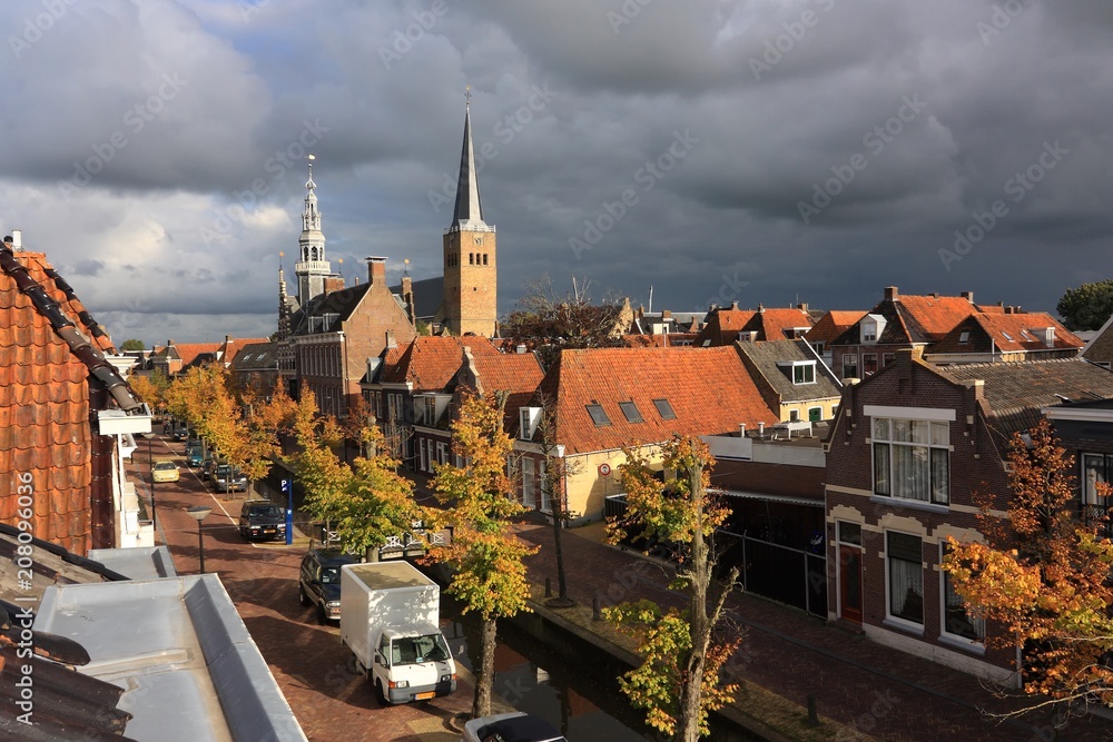 Fototapeta premium View on Franeker The Netherlands from Noord with Martinikerk and old city hall against a stormy sky in autumn