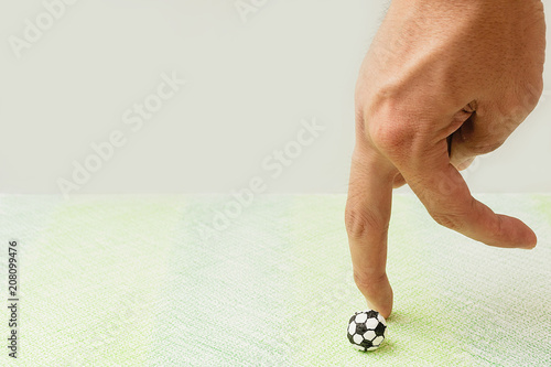 Human use the hand to play football made by paper on the  paper painted green ground,Playing socker paper by finger