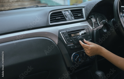 Hand driver touching the screen and turning on car radio system,Button on dashboard in car panel