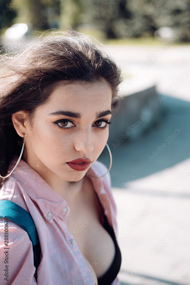 Woman on calm face with make up, urban background, defocused. Girl with big  earrings wears unbuttoned shirt and black bra. Lady with nude chest and  breasts looks attractive. Attraction concept Stock Photo |