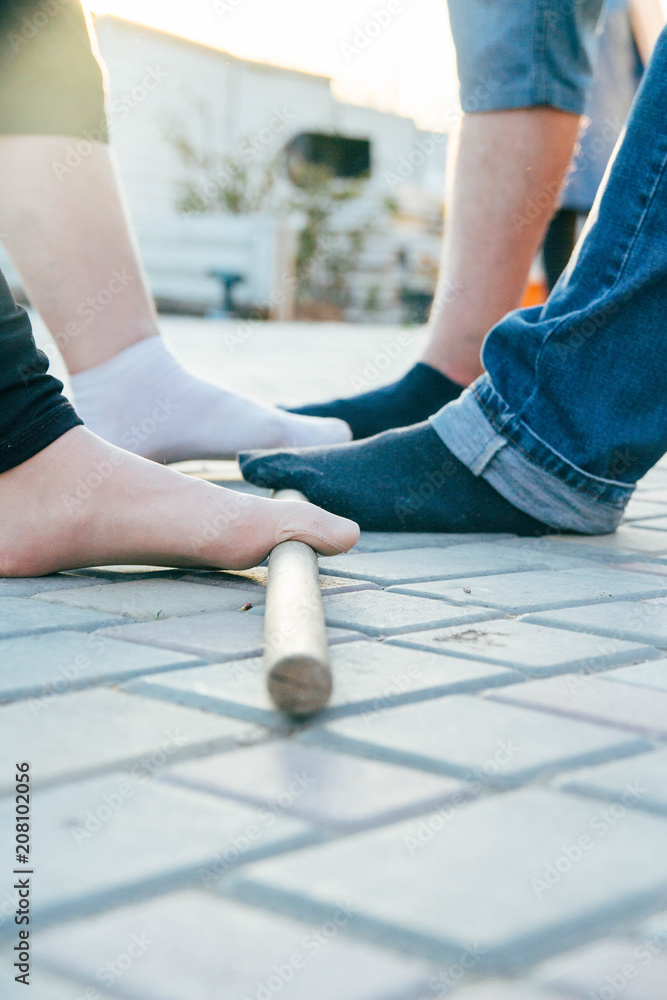 teambuilding activity with a stick and feet. collective support and assistance. colleagues.